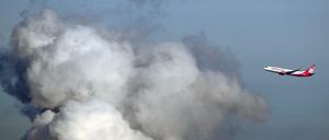 Ein Flugzeug der Airline "Air Berlin" fliegt an einer riesigen Wasserdampfwolke des Heizkraftwerkes Reuter in Siemensstadt vorbei.