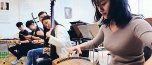 Traditionelle chinesische Instrumente. Jiakang Zhang (r.) spielt eine Guzheng, zu Deutsch: Wölbbrettzither. 