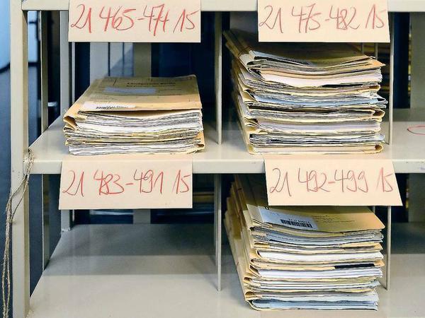 Auf jedem Stapel steht eine Zahlenkombination, die sich im Karteikartenkasten der Registratur wiederfindet.