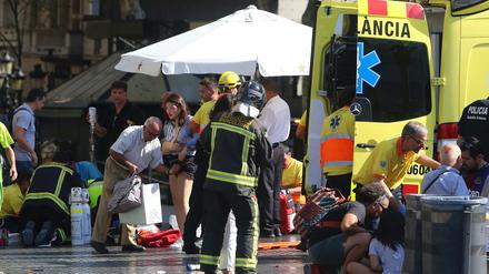 Sanitäter versorgen verletzte Menschen. Auf der Flaniermeile Las Ramblas ist ein Lieferwagen in eine Menschenmenge gerast. Es hat Tote und Verletzte gegeben. 