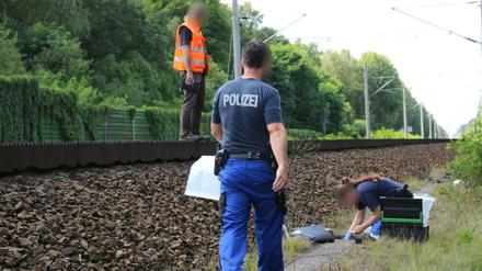 Mitarbeiter der Bahn und der Kriminalpolizei untersuchen am 19.07.2017 am Gleisbett einen Kabelschacht an der Bahnstrecke in der Nähe von Groß Behnitz bei Berlin.