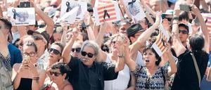 Nach einer Schweigeminute im Gedenken an die Opfer des Terrors vom Vortag applaudieren die Menschen auf der Placa de Catalunya in Barcelona.