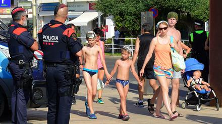 Die Polizei patrouilliert, Badegäste spazieren vorbei. Ein Bild aus Cambrils am Freitag.