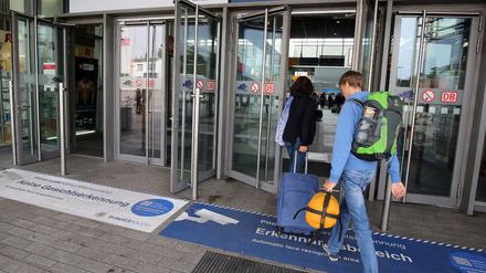 Passanten nutzen in Berlin am Bahnhof Südkreuz einen Eingang der mit "Pilotprojekt zur Gesichtserkennung" gekennzeichnet ist. 