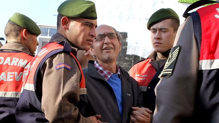 Der türkisch-stämmige Autor Dogan Akhanli wird am 08.12.2010 von Polizeibeamten zum Gericht in Istanbul gebracht.