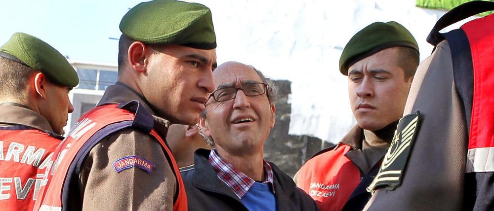 Der türkisch-stämmige Autor Dogan Akhanli wird am 08.12.2010 von Polizeibeamten zum Gericht in Istanbul gebracht.