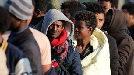 Flüchtlinge warten in der Nähe des geräumten "Dschungel von Calais" an einer Essensausgabe.