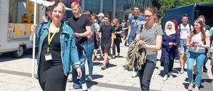 Eine Unimitarbeiterin führt eine Gruppe von Studieninteressierten über den Campus.