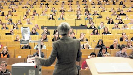 Eine Professorin steht im Hörsaal vor Studierenden.