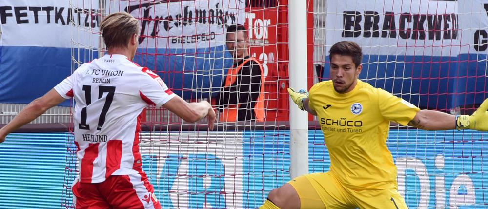 Simon Hedlund vom 1. FC Union und Torwart Stefan Ortega von Arminia Bielefeld kämpfen um den Ball.
