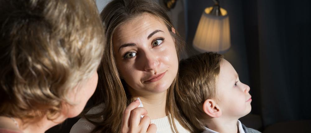 Aged woman is comforting emotional daughter after watching film at home.