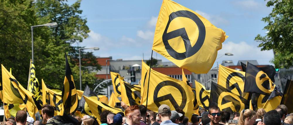 Anhänger der rechtsextremen Identitären Bewegung stehen in Berlin mit Fahnen auf der Brunnenstraße.