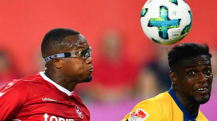 Kaiserslauterns Gervane Kastaneer (l) und Braunschweigs Joseph Baffo schauen auf den Ball.