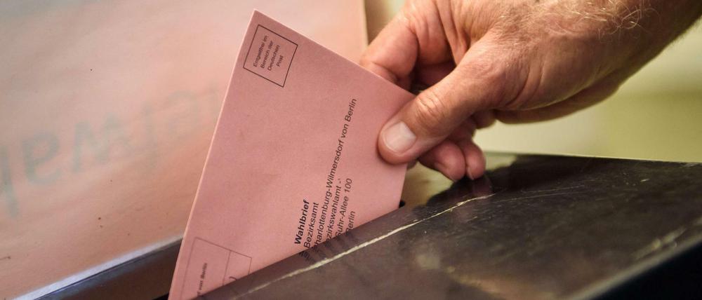 Ein Wähler wirft seinen ausgefüllten Wahlzettel für die Bundestagswahl in Berlin in eine Wahlurne.