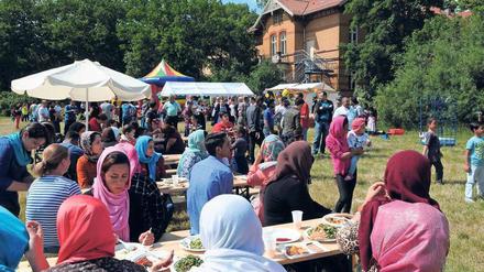 Hallo Nachbar. Hier feiern Flüchtlinge und Helfer der Marzahner Notunterkunft mit Anwohnern im nahen Park. 