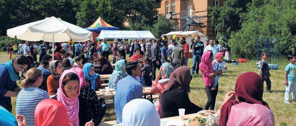Hallo Nachbar. Hier feiern Flüchtlinge und Helfer der Marzahner Notunterkunft mit Anwohnern im nahen Park.