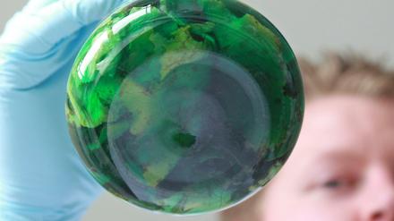 Ein Chemiker schwenkt ein Glasgefäß mit einer Lebensmittelprobe