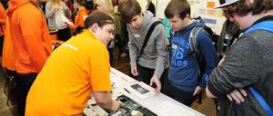 Jugendliche sind bei einer Ausbildungsmesse im Gespräch mit Vertretern von Betrieben.