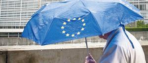 Ein Fußgänger vor dem EU-Kommissionsgebäude im Brüsseler Regen. 