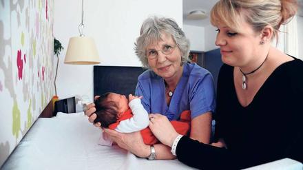 Stützende Hände. Hebammen helfen jungen Müttern, in ihre neue Aufgabe hineinzuwachsen. 