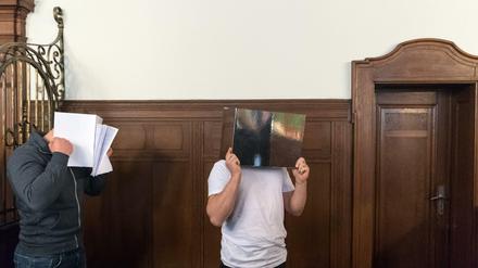 Die Angeklagten stehen am 13.09.2017 zu Prozessbeginn im Saal 621 des Landgerichts Berlin und verdecken ihr Gesicht. Die Männer sind wegen des brutalen Mordes an dem Musiker Jim Reeves in einem Berliner Hostel angeklagt. Der Sänger der Band Sqeezer war am 01. Februar 2016 getötet worden. 