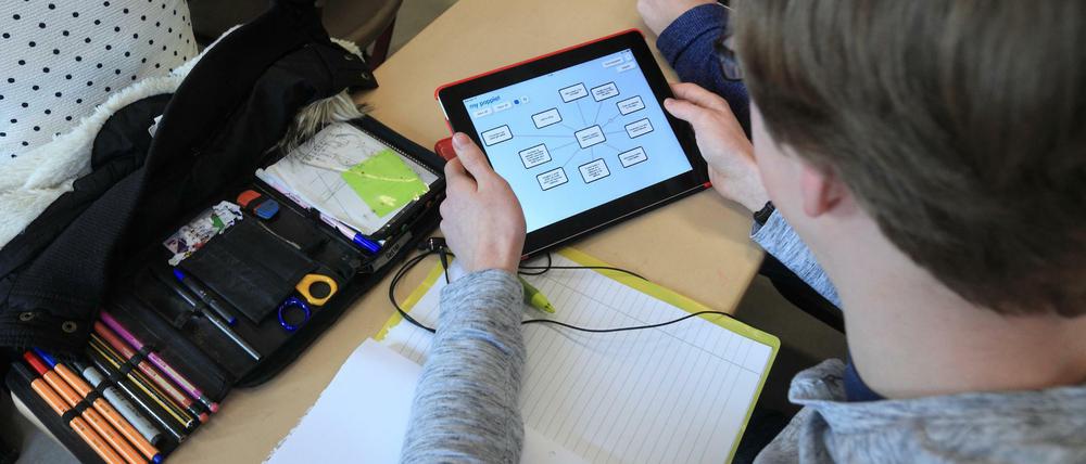 Ein Schüler arbeitet im Klassenraum mit einem Tablet-Computer.
