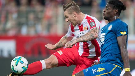 Unions Sebastian Polter schießt den Ball gegen Braunschweigs Joseph Baffo (r). 
