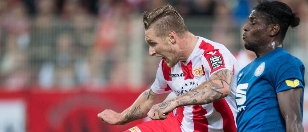 Unions Sebastian Polter schießt den Ball gegen Braunschweigs Joseph Baffo (r).