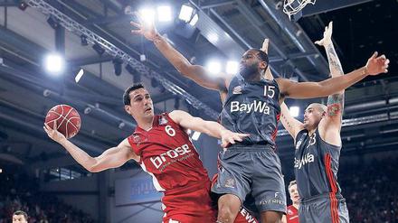 Riesiger Zweikampf. Die finanzstärksten deutschen Klubs, Bamberg und FC Bayern, duellieren sich ständig – im Bild Bambergs Nikos Zisis (links) und Reggie Redding (Mitte). Für einen Sieg im Europapokal reichte es für beide Teams bisher aber nicht. Foto: Daniel Löb/dpa