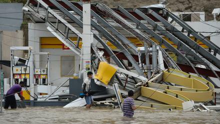Menschen waten in Humacao, Puerto Rico durch überflutete Straßen.