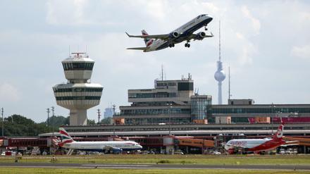Blick auf das Hauptterminal des Flughafens Tegel, davor Flugzeuge, im Hintergrund der Fernsehturm.