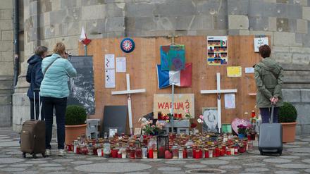 Menschen stehen in Berlin an der Gedenkstätte für die Opfer des Terroranschlages vom Breitscheidplatz. 