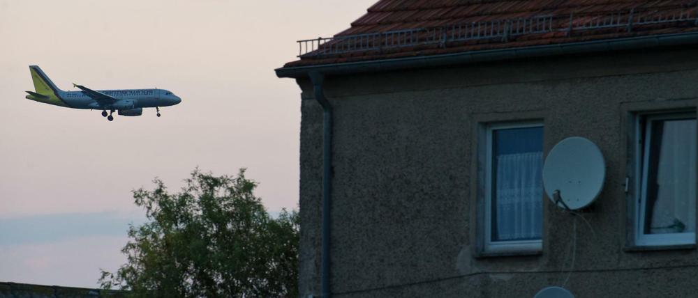 Ein Passagierflugzeug befindet sich im Landeanflug über den Dächern von Häusern im Ort Sielow unweit dem Flughafen Schönefeld. 
