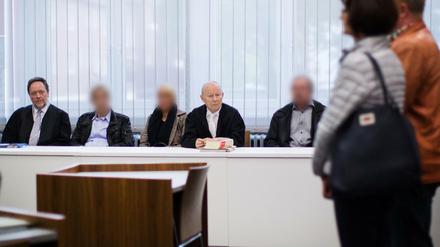 Die Angeklagten im Gerichtssaal neben ihren Anwälten.