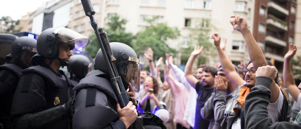 Einsatzkräfte der Guardia Civil treffen vor einer Schule in Barcelona auf Unterstützer des Referendums.