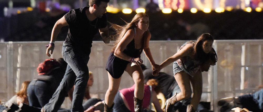 Besucher des Festivals in Las Vegas rennen vom Gelände, nachdem Schüsse gefallen sind.