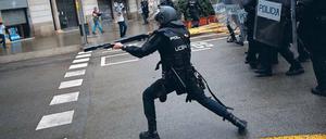 Ein spanischer Nationalpolizist zielt in Barcelona auf Menschen, die in einer Schule ihre Stimme abgeben wollen.