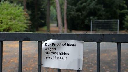 Friedhofsbesucher stehen vor verschlossenen Toren.