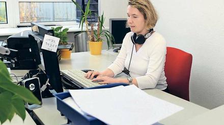 Alleskönnerin: Obwohl Christine Günzel blind ist, produziert sie die Taubblindenzeitung in Eigenregie. Im Vordergrund die fertige Zeitung – ohne Bilder, aber in der gestanzten Blindenschrift.