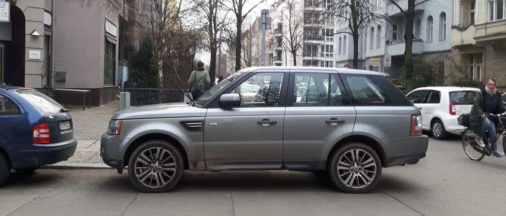 Falschparkender SUV blockiert Übergang für Fußgänger und Fahrt für Radfahrer.