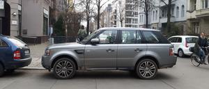 Falschparkender SUV blockiert Übergang für Fußgänger und Fahrt für Radfahrer.