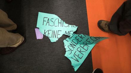Ein zerrissenes Protestplakat lautet: "Faschismus ist keine Meinung, sondern ein Verbrechen." 
