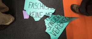 Ein zerrissenes Protestplakat lautet: "Faschismus ist keine Meinung, sondern ein Verbrechen." 