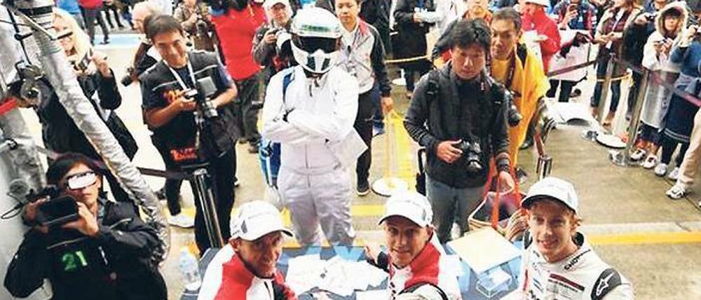 Timo Bernhard, Earl Bamber und Brendon Hartley (von links) freuen sich über den Besuch der Fans bei der Autogrammstunde.