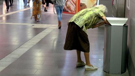 Eine alte Frau sammelt Flaschen aus Abfalleimern im Hauptbahnhof in Muelheim an der Ruhr. 