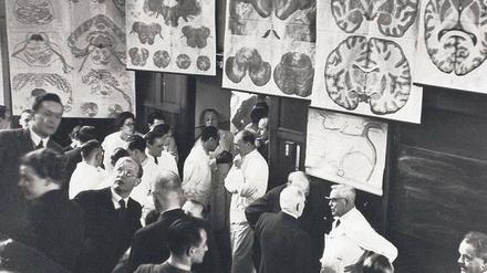 Experten unter sich: Der Leiter der damaligen Psychiatrischen- und Nervenklinik Karl Bonhoeffer (re. im weißen Kittel) bei seiner Abschiedsvorlesung 1938 im Gespräch mit dem Chirurgen Ferdinand Sauerbruch (re. von ihm) und dem Gynäkologen Walter Stoeckel (li. von ihm). Ganz links im Bild (mit Brille, sich umwendend) sein Sohn, der Theologe Dietrich Bonhoeffer. 