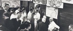 Experten unter sich: Der Leiter der damaligen Psychiatrischen- und Nervenklinik Karl Bonhoeffer (re. im weißen Kittel) bei seiner Abschiedsvorlesung 1938 im Gespräch mit dem Chirurgen Ferdinand Sauerbruch (re. von ihm) und dem Gynäkologen Walter Stoeckel (li. von ihm). Ganz links im Bild (mit Brille, sich umwendend) sein Sohn, der Theologe Dietrich Bonhoeffer. 