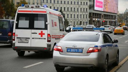 Ein Krankenwagen fährt in Moskau an einem Polizeiauto vorbei, das vor der Radiostation des Senders Ekho Moskvy parkt. 