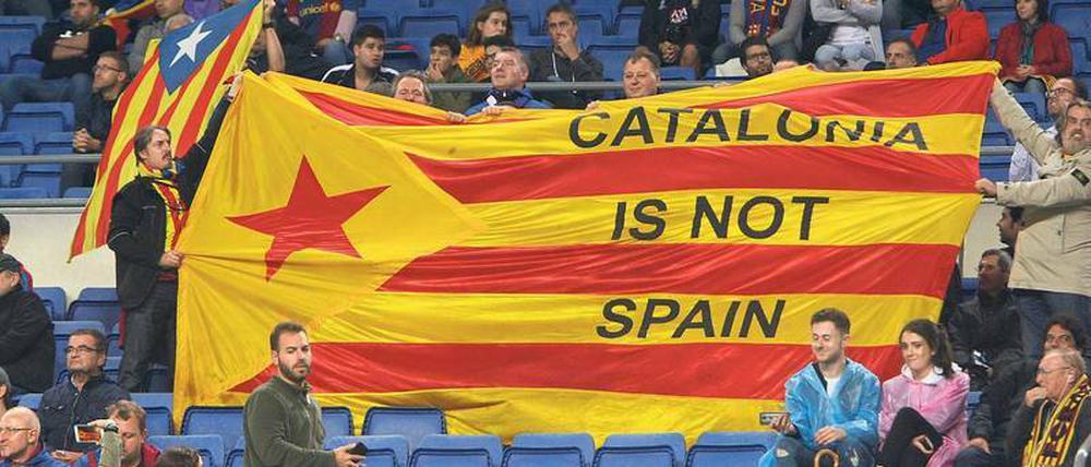 Auf der Tribüne beim FC Barcelona. Fans des 24-maligen spanischen Fußballmeisters halten eine Fahne mit der Aufschrift „Katalonien ist nicht Spanien“ hoch.