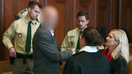 Der Angeklagte Wolfgang P. (M), begrüßt zu Verhandlungsbeginn seine Anwältin Susanne Koller (r). 